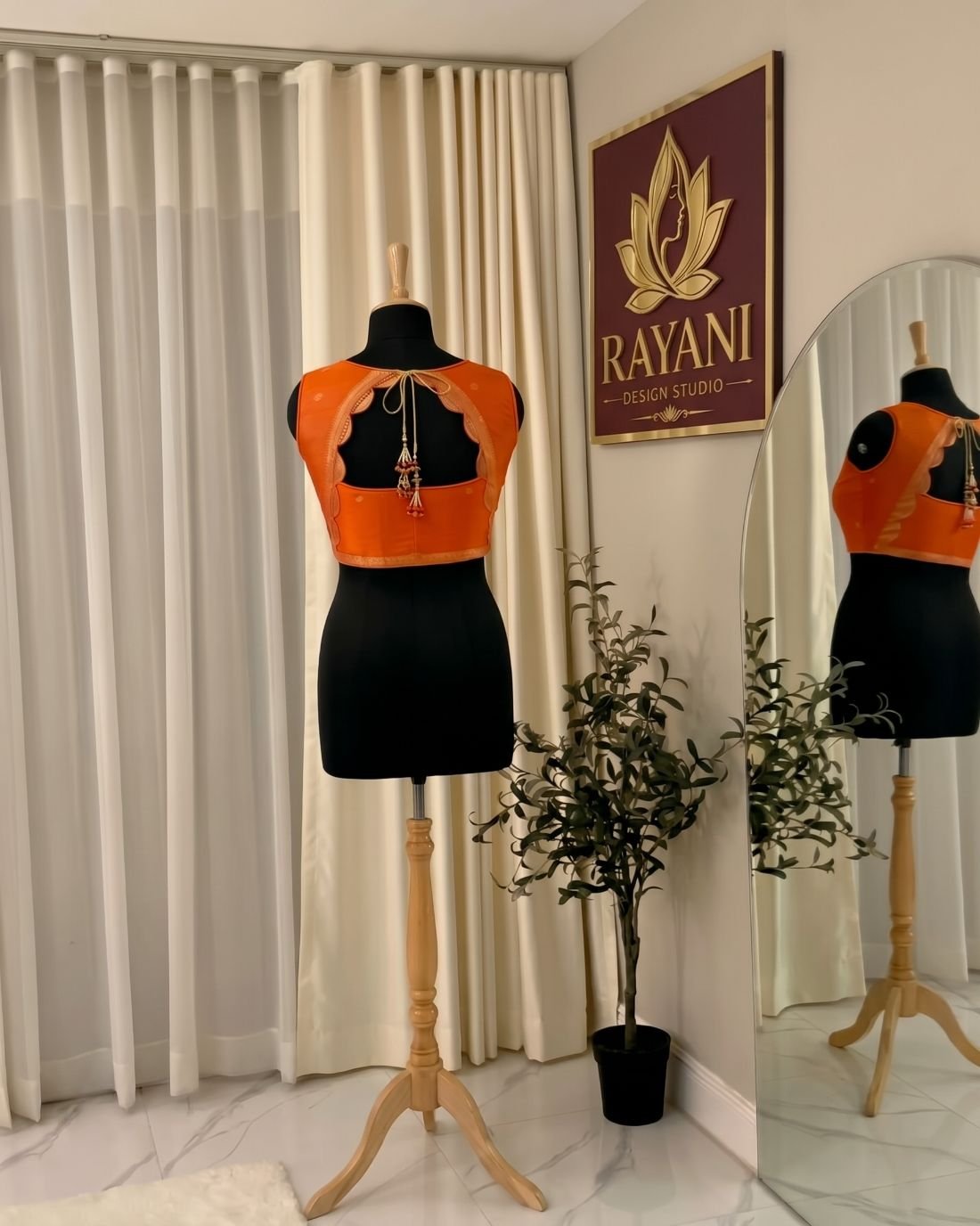 Orange silk blouse with a scalloped open back and latkan tassels